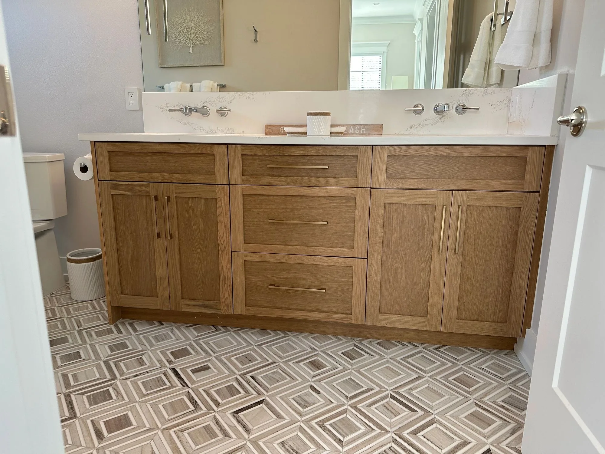 A white oak double vanity with brass pulls